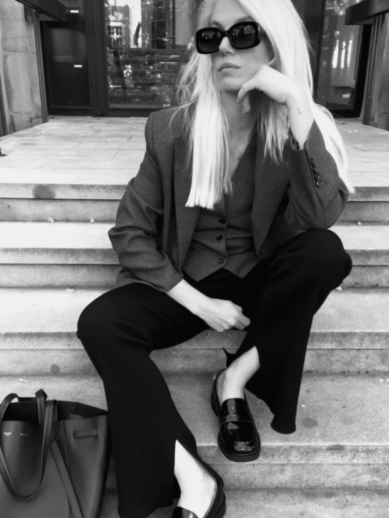 Jenny Gold in stilvollem Blazer-Look auf einer Treppe